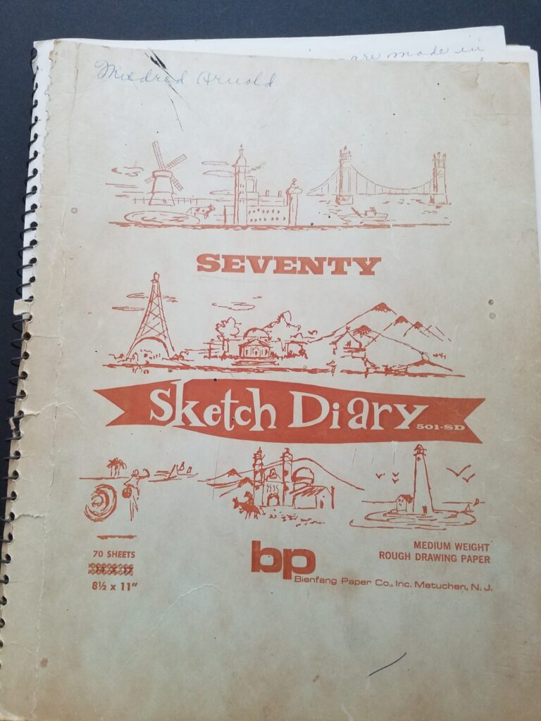 Sketch Diary 1 Cover of a spiral notebook with the graphic title sketch diary. The name Mildred Arnold is written in blue ink at the top.