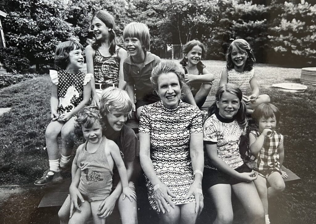 Black and white photograph from 1967 of Mildred, seated, surrounded by her nine grand-children. There is but one boy among them. And he's the kid who built this site.