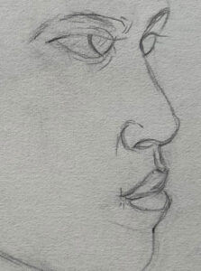 Detail of a boys face in profile showing just the eyes, nose, and mouth.